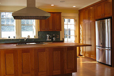Mid-sized arts and crafts l-shaped medium tone wood floor and brown floor eat-in kitchen photo in Boston with ceramic backsplash, an island, shaker cabinets, medium tone wood cabinets, wood countertops, blue backsplash and stainless steel appliances