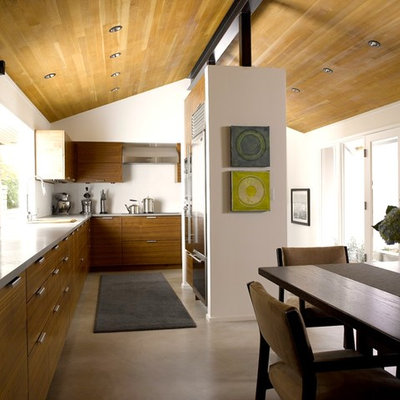 Mid-sized trendy l-shaped concrete floor and gray floor eat-in kitchen photo in Seattle with stainless steel appliances, an undermount sink, flat-panel cabinets, medium tone wood cabinets, concrete countertops, no island and gray countertops