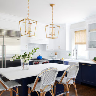 Ispirazione per una cucina a L costiera di medie dimensioni con lavello stile country, paraspruzzi bianco, paraspruzzi con piastrelle diamantate, elettrodomestici in acciaio inossidabile, parquet scuro, isola, pavimento marrone, top bianco, ante con riquadro incassato e ante blu
