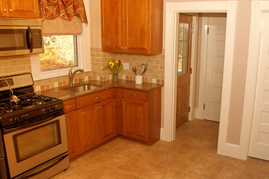 Example of a mid-sized classic l-shaped linoleum floor kitchen pantry design in Boston with a single-bowl sink, raised-panel cabinets, medium tone wood cabinets, quartz countertops, beige backsplash, ceramic backsplash, stainless steel appliances and an island