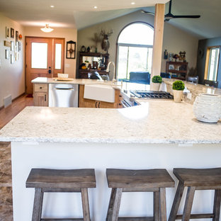 Immagine di una grande cucina stile rurale con lavello sottopiano, ante con riquadro incassato, ante viola, paraspruzzi beige, elettrodomestici in acciaio inossidabile, pavimento in vinile, isola e top in granito