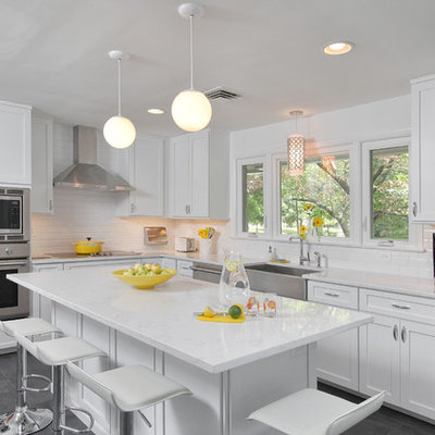 Mid-sized transitional l-shaped slate floor open concept kitchen photo in Philadelphia with a farmhouse sink, shaker cabinets, white cabinets, white backsplash, subway tile backsplash, stainless steel appliances, an island and marble countertops