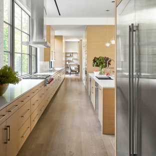 Contemporary kitchen ideas - Trendy galley medium tone wood floor and brown floor kitchen photo in Dallas with an undermount sink, flat-panel cabinets, medium tone wood cabinets, white backsplash, window backsplash, stainless steel appliances, an island and white countertops