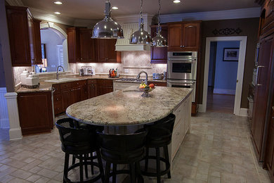 Example of a large u-shaped ceramic tile enclosed kitchen design in Charlotte with a farmhouse sink, raised-panel cabinets, dark wood cabinets, granite countertops, multicolored backsplash, ceramic backsplash, stainless steel appliances and an island