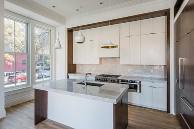 Mid-sized minimalist l-shaped medium tone wood floor and brown floor open concept kitchen photo in New York with an undermount sink, flat-panel cabinets, white cabinets, quartzite countertops, beige backsplash, stone slab backsplash, an island and paneled appliances