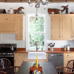 Design ideas for a small country single-wall eat-in kitchen in Raleigh with a farmhouse sink, shaker cabinets, orange cabinets, stainless steel appliances, brick floors, orange benchtop, wood benchtops, no island, brown floor and exposed beam.