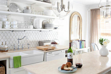 Photo of a traditional kitchen in Phoenix with a double-bowl sink, open cabinets, white cabinets and white splashback.