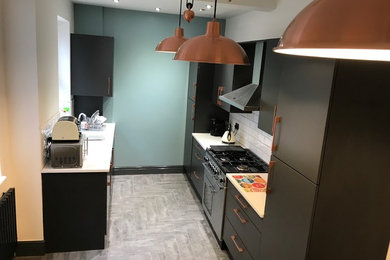 Geschlossene, Kleine Moderne Küche ohne Insel in L-Form mit Einbauwaschbecken, grauem Boden und weißer Arbeitsplatte in Manchester