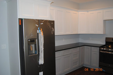 ボストンにあるおしゃれなコの字型キッチン (落し込みパネル扉のキャビネット、御影石カウンター、シルバーの調理設備) の写真