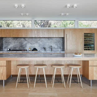 Inspiration for a large contemporary galley open plan kitchen in Melbourne with an undermount sink, flat-panel cabinets, medium wood cabinets, grey splashback, panelled appliances, with island, marble benchtops, stone slab splashback, travertine floors, beige floor and grey benchtop.