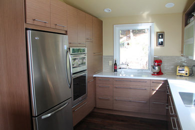 Minimalist u-shaped eat-in kitchen photo in San Francisco with an undermount sink, flat-panel cabinets, medium tone wood cabinets, marble countertops, green backsplash, glass tile backsplash and stainless steel appliances