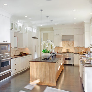 Aménagement d'une cuisine américaine classique en U de taille moyenne avec un évier encastré, un placard à porte shaker, des portes de placard blanches, un plan de travail en quartz modifié, une crédence multicolore, une crédence en mosaïque, un électroménager en acier inoxydable, un sol en contreplaqué et un îlot central.