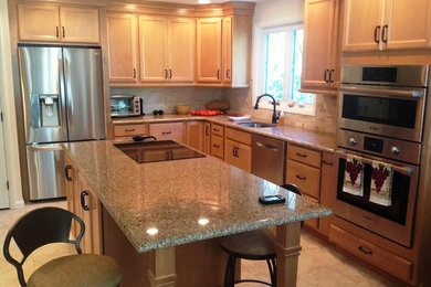 Example of a mid-sized classic u-shaped ceramic tile eat-in kitchen design in Other with an undermount sink, recessed-panel cabinets, light wood cabinets, granite countertops, beige backsplash, ceramic backsplash, stainless steel appliances and an island