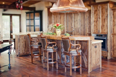 Eat-in kitchen - mid-sized craftsman l-shaped medium tone wood floor eat-in kitchen idea in San Francisco with a farmhouse sink, raised-panel cabinets, medium tone wood cabinets, limestone countertops and stainless steel appliances