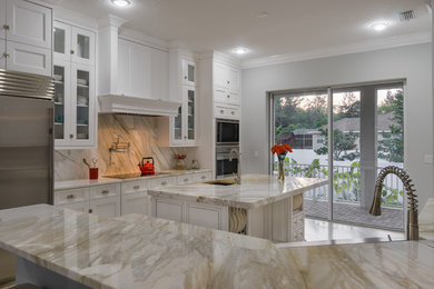 Medium sized modern enclosed kitchen in Tampa with a submerged sink, white cabinets, marble worktops, stone slab splashback, stainless steel appliances, ceramic flooring and an island.