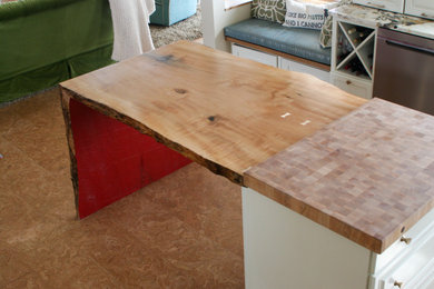 Example of a trendy eat-in kitchen design in Other with wood countertops and an island