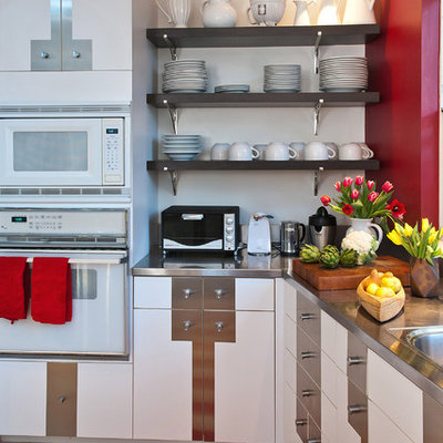 Eat-in kitchen - large eclectic limestone floor and beige floor eat-in kitchen idea in San Francisco with white appliances, stainless steel countertops, white cabinets, a drop-in sink, flat-panel cabinets, gray backsplash, metal backsplash and a peninsula