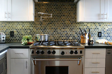 Klassisk inredning av ett stort kök, med en undermonterad diskho, skåp i shakerstil, vita skåp, bänkskiva i kvartsit, flerfärgad stänkskydd, stänkskydd i stenkakel, rostfria vitvaror och mellanmörkt trägolv