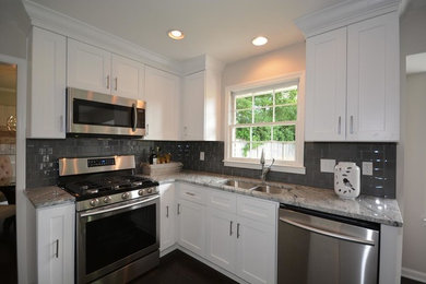 Example of a mid-sized minimalist l-shaped dark wood floor and brown floor eat-in kitchen design in Atlanta with a double-bowl sink, shaker cabinets, white cabinets, gray backsplash, subway tile backsplash, stainless steel appliances, no island and marble countertops