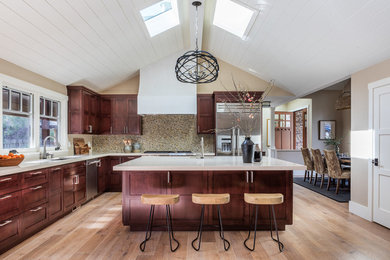 Inspiration for a large craftsman l-shaped light wood floor kitchen remodel in San Francisco with an undermount sink, shaker cabinets, medium tone wood cabinets, quartz countertops, beige backsplash, glass tile backsplash, stainless steel appliances and an island