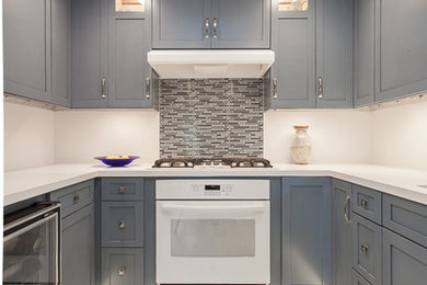 Mid-sized trendy u-shaped porcelain tile eat-in kitchen photo in Los Angeles with an undermount sink, shaker cabinets, blue cabinets, white backsplash and white appliances