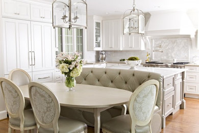 Example of a kitchen design in Charlotte with white cabinets and an island