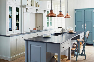Medium sized classic galley kitchen/diner in Other with shaker cabinets, black worktops, a submerged sink, grey cabinets, grey splashback, medium hardwood flooring, multiple islands and brown floors.