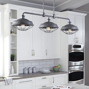 Inspiration for a mid-sized industrial kitchen in Other with an integrated sink, recessed-panel cabinets, white cabinets, soapstone benchtops, white splashback, stainless steel appliances, with island and subway tile splashback.