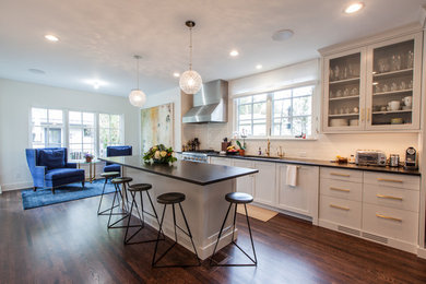 Trendy dark wood floor and brown floor kitchen photo in Minneapolis with an undermount sink, flat-panel cabinets, white cabinets, white backsplash, ceramic backsplash, stainless steel appliances and an island