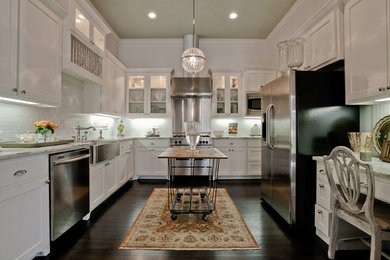 Inspiration for a timeless u-shaped enclosed kitchen remodel in Atlanta with a farmhouse sink, shaker cabinets, white cabinets, white backsplash, subway tile backsplash and stainless steel appliances