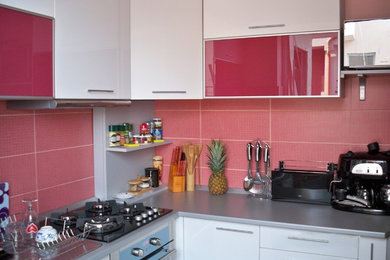 Foto di una cucina contemporanea con lavello integrato, ante di vetro, ante bianche, paraspruzzi rosso, paraspruzzi con piastrelle diamantate e elettrodomestici in acciaio inossidabile