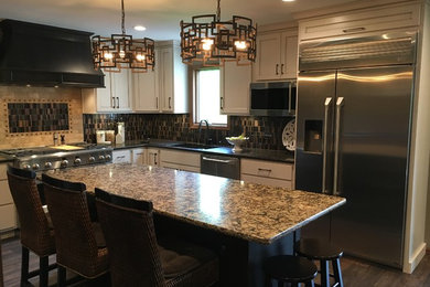 Mid-sized trendy l-shaped dark wood floor and brown floor eat-in kitchen photo in Other with an undermount sink, white cabinets, quartzite countertops, multicolored backsplash, glass tile backsplash, stainless steel appliances, an island and multicolored countertops