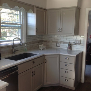 Traditional enclosed kitchen appliance - Example of a classic galley dark wood floor enclosed kitchen design in Seattle with an undermount sink, beaded inset cabinets, gray cabinets, quartz countertops, white backsplash, ceramic backsplash, stainless steel appliances and no island