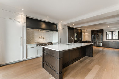 Inspiration for a huge contemporary galley light wood floor and beige floor eat-in kitchen remodel in Montreal with an island, an undermount sink, shaker cabinets, white cabinets, solid surface countertops, white backsplash, stone tile backsplash and paneled appliances