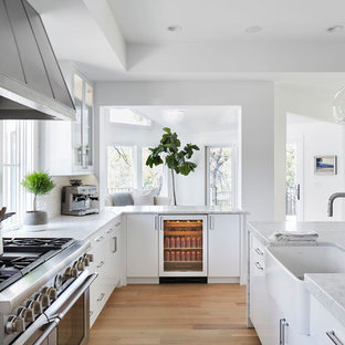 Immagine di una cucina design di medie dimensioni con lavello stile country, ante lisce, ante bianche, top in marmo, paraspruzzi bianco, elettrodomestici in acciaio inossidabile, parquet chiaro, isola, paraspruzzi con piastrelle diamantate e pavimento beige