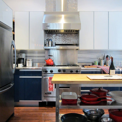Inspiration for a contemporary kitchen remodel in San Francisco with stainless steel appliances, flat-panel cabinets, white cabinets, stainless steel countertops, white backsplash and marble backsplash