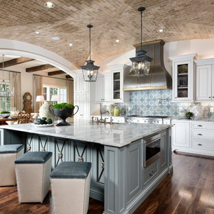 Large mediterranean open concept kitchen ideas - Open concept kitchen - large mediterranean l-shaped dark wood floor and brown floor open concept kitchen idea in Nashville with a farmhouse sink, white cabinets, granite countertops, blue backsplash, ceramic backsplash, stainless steel appliances, an island and raised-panel cabinets