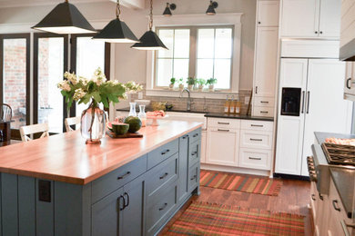 Eat-in kitchen - large cottage single-wall medium tone wood floor, brown floor and coffered ceiling eat-in kitchen idea in Other with a farmhouse sink, shaker cabinets, white cabinets, granite countertops, blue backsplash, subway tile backsplash, paneled appliances, an island and black countertops