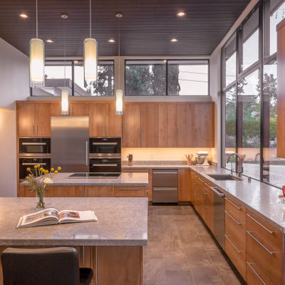 Kitchen - large 1950s u-shaped gray floor and porcelain tile kitchen idea in San Francisco with flat-panel cabinets, light wood cabinets, window backsplash, stainless steel appliances, two islands, gray countertops, an undermount sink, quartz countertops and gray backsplash