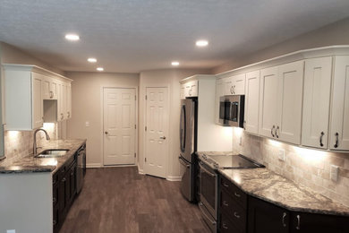 Inspiration for a small transitional galley laminate floor and brown floor eat-in kitchen remodel in Cleveland with an undermount sink, shaker cabinets, white cabinets, quartz countertops, beige backsplash, stone tile backsplash, stainless steel appliances and beige countertops