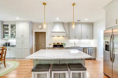 Eat-in kitchen - mid-sized transitional galley light wood floor and brown floor eat-in kitchen idea in Birmingham with an undermount sink, shaker cabinets, gray cabinets, quartzite countertops, white backsplash, subway tile backsplash, stainless steel appliances, an island and white countertops