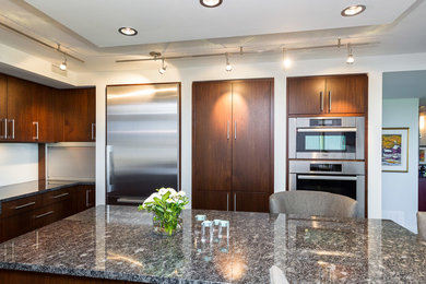 Geschlossene, Mittelgroße Moderne Küche in L-Form mit flächenbündigen Schrankfronten, hellbraunen Holzschränken, Granit-Arbeitsplatte, Küchengeräten aus Edelstahl und Kücheninsel in Edmonton