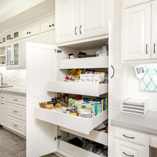 Inspiration for a small traditional separate kitchen in Los Angeles with an undermount sink, glass-front cabinets, white cabinets, quartz benchtops, beige splashback, ceramic splashback, stainless steel appliances and porcelain floors.