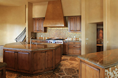 Example of a large mountain style slate floor and brown floor kitchen design in Phoenix with an undermount sink, raised-panel cabinets, dark wood cabinets, granite countertops, multicolored backsplash, mosaic tile backsplash and an island
