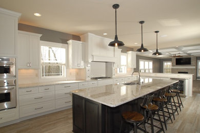 Large transitional galley porcelain tile and beige floor eat-in kitchen photo in Milwaukee with an undermount sink, raised-panel cabinets, white cabinets, granite countertops, white backsplash, subway tile backsplash, stainless steel appliances and an island