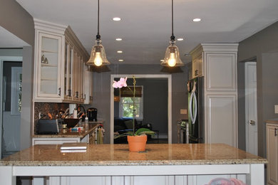 Mid-sized transitional u-shaped dark wood floor and brown floor eat-in kitchen photo in New York with a double-bowl sink, raised-panel cabinets, white cabinets, soapstone countertops, beige backsplash, stone tile backsplash, stainless steel appliances and an island