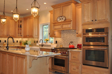 Example of a large classic u-shaped ceramic tile eat-in kitchen design in New York with a farmhouse sink, recessed-panel cabinets, light wood cabinets, granite countertops, multicolored backsplash, ceramic backsplash, stainless steel appliances and an island