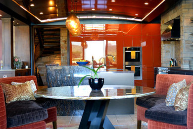 Foto de cocina comedor actual grande con puertas de armario naranjas, encimera de granito y una isla
