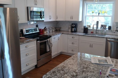 Eat-in kitchen - mid-sized transitional u-shaped medium tone wood floor eat-in kitchen idea in Richmond with an undermount sink, shaker cabinets, white cabinets, granite countertops, white backsplash, subway tile backsplash and stainless steel appliances