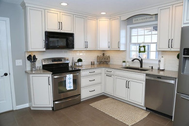 Example of a mid-sized classic l-shaped ceramic tile eat-in kitchen design in Chicago with an undermount sink, shaker cabinets, white cabinets, quartz countertops, white backsplash, subway tile backsplash, stainless steel appliances and no island